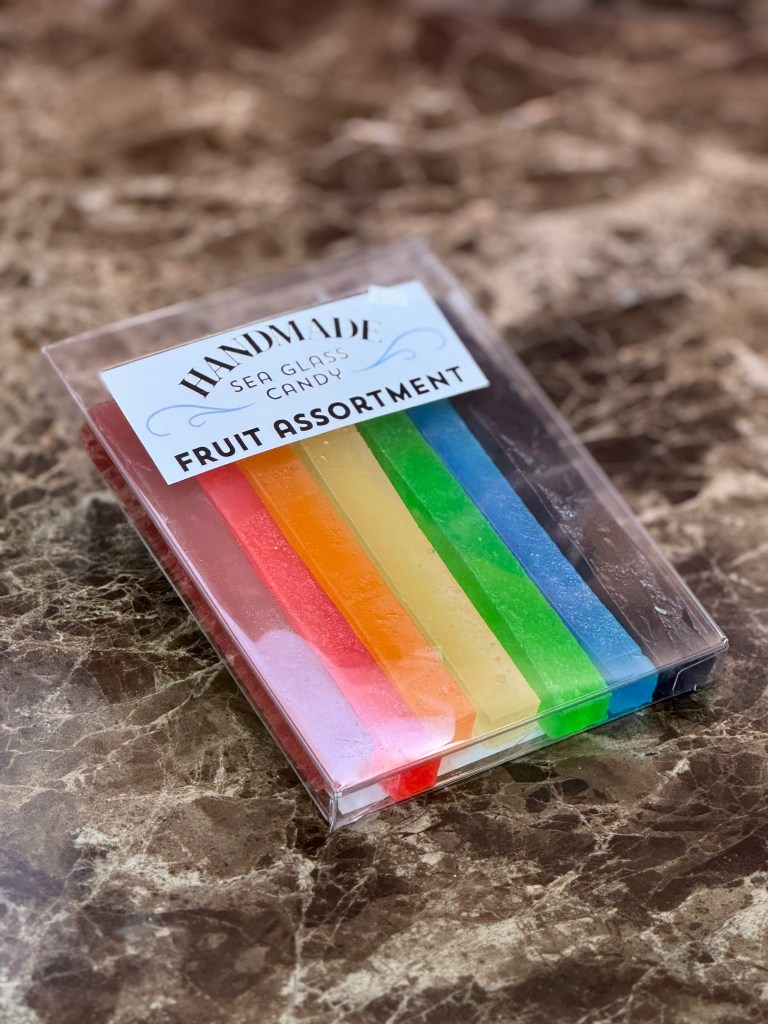 Photo of a package of handmade sea glass candy in fruit assortment--it contains 7 sticks in a rainbow of colors.